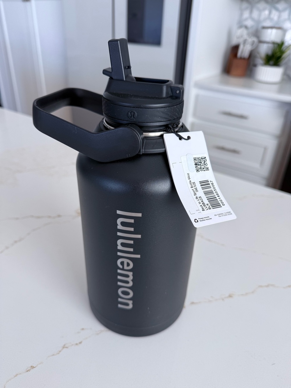Lululemon 64 Oz black insulated water bottle with a carry handle.